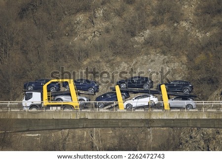 Automotive industry and car transportation. Truck transporting cars on the bridge. No logo, brand. Royalty-Free Stock Photo #2262472743