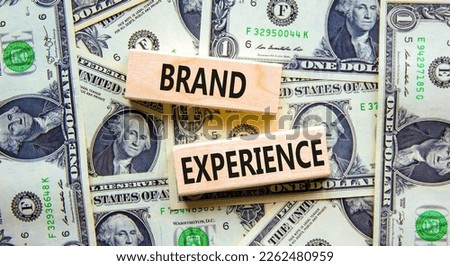 Brand experience symbol. Concept words Brand experience on wooden blocks. Beautiful background from dollar bills. Business branding and brand experience concept. Copy space.