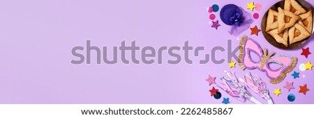 Purim carnival background with traditional cookies, costume accessories and decor on pastel violet background, web banner, copy space