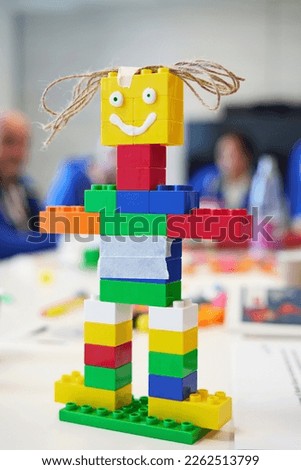Smiling toy robot made from plastic colorful blocks