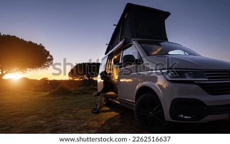 man sitting with digital device at his Transporter Camping Van bus at the California Ocean in the coastal Nature - digital nomades concept Royalty-Free Stock Photo #2262516637