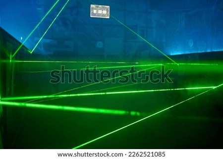 Bright green neon laser lights illuminate the darkness creating lines and triangle shapes in sci-fi effect