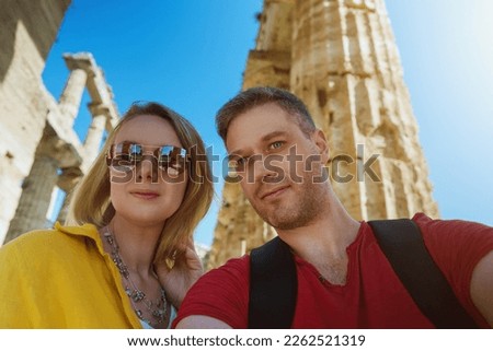 Couple take selfie in front of the remains of the ancient temple.