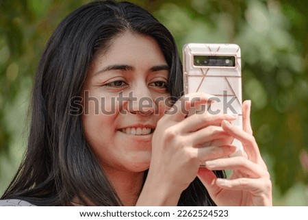 Hispanic girl taking pictures in desert garden