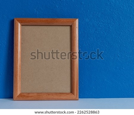 wooden portrait frame on blue wall