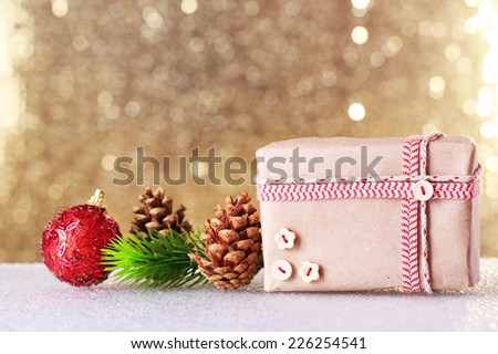 Gift box and Christmas decor on table on shiny background