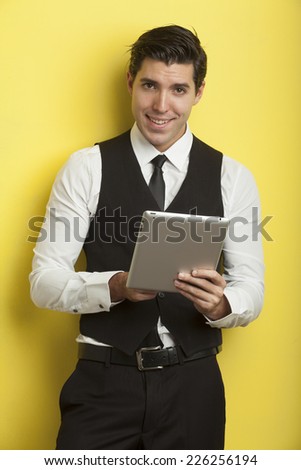 young businessmen on yellow background holding tablet