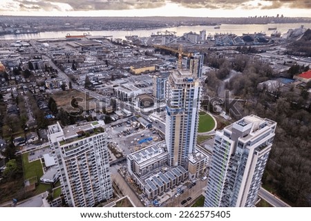 Aerial drone footage sunrise apartment buildings and crane at construction site, sunrise skyscrapers, condominiums, real estate, North Vancouver.