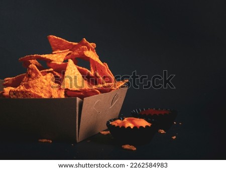 a bowl of triangular-shaped Doritos chips with a cheese-flavored seasoning. The combination looks delicious and makes for a snack Royalty-Free Stock Photo #2262584983