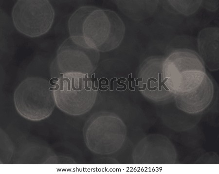 Grey and white bokeh effect and purposely blurred view of sunlight reflection. Bright, shining background. Blurry background with photographic bokeh effect in beautiful neutral tones