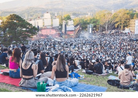 Group of young women watching concert in the park at open air music festival, back view. Royalty-Free Stock Photo #2262621967