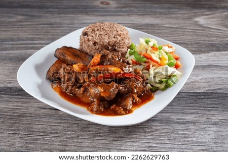 A view of a plate of brown stew chicken. Royalty-Free Stock Photo #2262629763