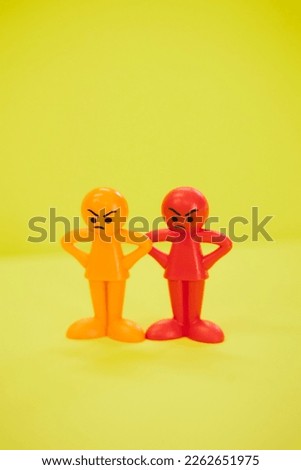 Angry colorful doll on yellow background