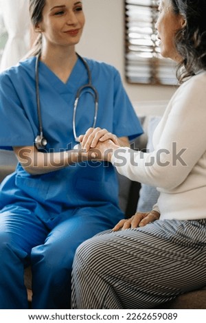Female hands touching old female hand Helping hands take care of the elderly concept in  hospital Royalty-Free Stock Photo #2262659089