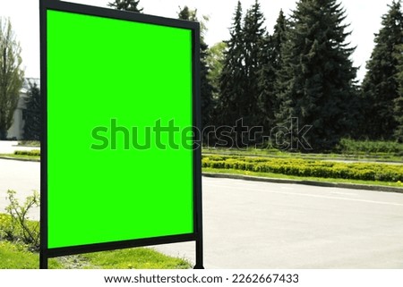 Chroma key compositing. Empty billboard with green screen outdoors. Mockup for design