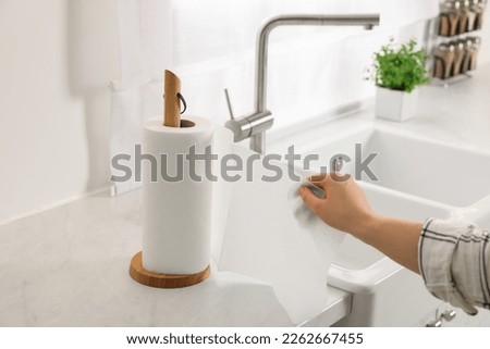 Woman using paper towels in kitchen, closeup Royalty-Free Stock Photo #2262667455