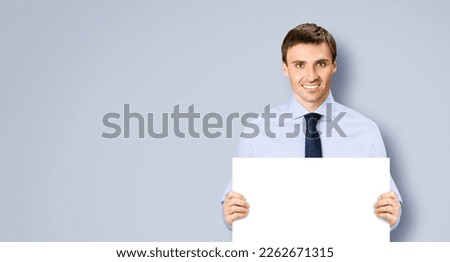 Portrait image of business man professional bank manager in confident cloth necktie holding showing empty white banner signboard paper poster with copy space area. Isolate on grey gray background