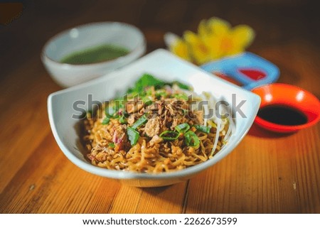 Asian fried chicken noodle in bowl blurred background 