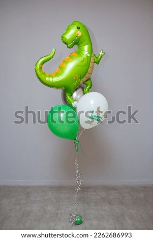 green dinosaur, foil balloon green dinosaur with latex balloons on the background of the wall, postcard with a dinosaur