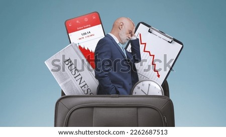 Stressed sad businessman and financial graphs showing loss in a briefcase, financial failure concept Royalty-Free Stock Photo #2262687513