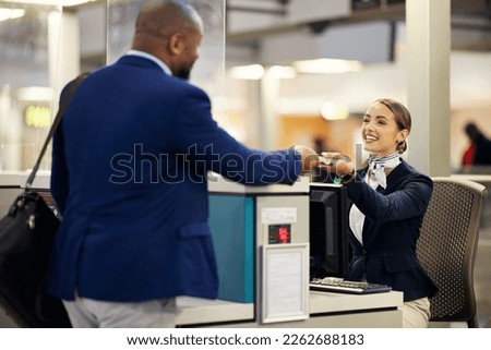 Businessman, airport and passenger assistant helping traveler with checkin at terminal counter. Black male with passport and service agent in travel help, security or immigration for airline control Royalty-Free Stock Photo #2262688183