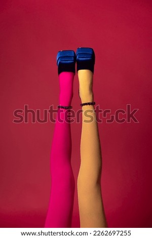 Advertising of colored bright tights, female legs in blue shoes, saturated background, beautiful color in modern trendy style, fashion
