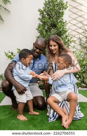 Mixed raced family sitting together with children fighting for the toy