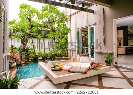 Living room design with modern sofa Fountain and frangipani trees shady Thai style and luxury accessories to decorate your home. selective focus, soft focus. Royalty-Free Stock Photo #2262712081