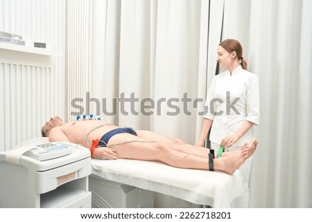 Professional doctor is doing electrocardiogram with modern device in the clinic