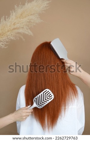 Beautiful female long red straight hair, massage combs, photo for the beauty industry, master, salon and hairdresser