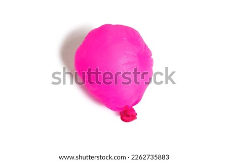 Half deflated pink balloon on a white background. One uninflated balloon top view. The concept of the ended holidays in the form of a half-deflated balloon Royalty-Free Stock Photo #2262735883