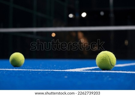 two balls on the surface of a blue paddle tennis court at night Royalty-Free Stock Photo #2262739203
