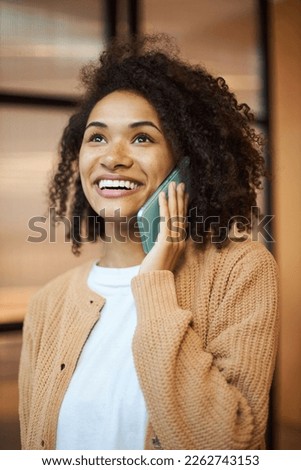 Closeup portrait of beautiful smiling African American young woman talking on mobile phone. Technology concept 