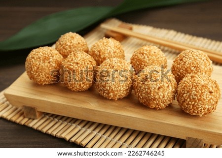 Many delicious sesame balls on wooden table, closeup