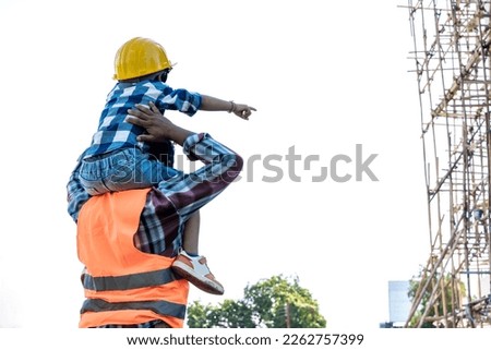 Back view engineer man carrying son on shoulder at construction site Royalty-Free Stock Photo #2262757399