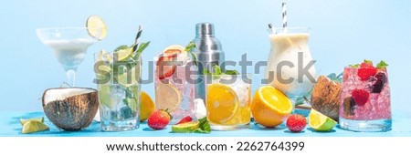 Summer cocktails drinks. Classic alcoholic long drink mocktail versions, various beverages, lemonades with berries, lime, orange, coconut, ice on light blue sunny sea beach bar background  Royalty-Free Stock Photo #2262764399