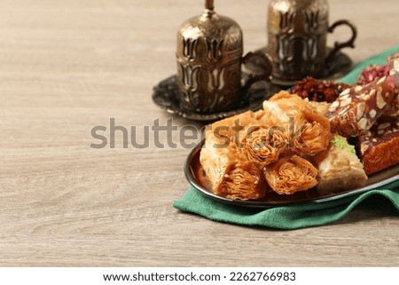 Tea, baklava dessert and Turkish delight served in vintage tea set on wooden table, space for text