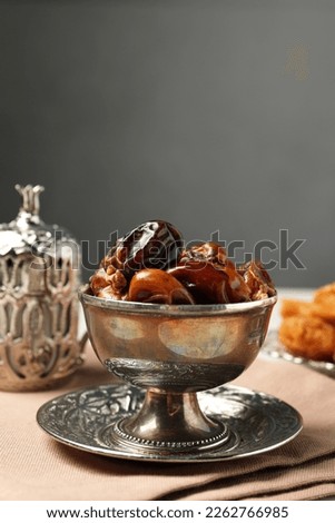 Tea and date fruits served in vintage tea set on white table, space for text