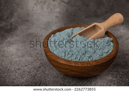 Blue spirulina powder in a bowl on a black marble background. Natural superfood, vegan, healthy food supplement. Phycocyanin extract. Antioxidant. Place for text. Copy space. Royalty-Free Stock Photo #2262773855