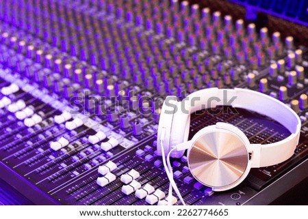 white headphone on audio mixing console. music, broadcasting, recording, music production, live concept