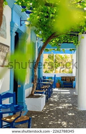 Typical Greek terrace with blue chairs in Pigadia, the capital of the Greek island Karpathos