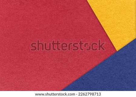 Texture of craft dark red paper background with yellow and blue border. Vintage abstract wine cardboard. Presentation template and mockup with copy space. Felt backdrop closeup.