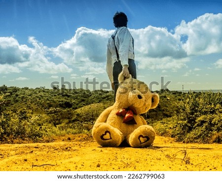 A Brokenhearted Man Dragging a Teddy Bear Up the Hill Royalty-Free Stock Photo #2262799063