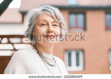 Outdoor close up portrait of beautiful 55 - 60 year old woman