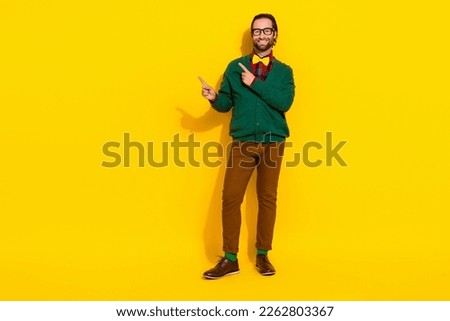 Full size photo of positive nice person indicate fingers empty space isolated on yellow color background