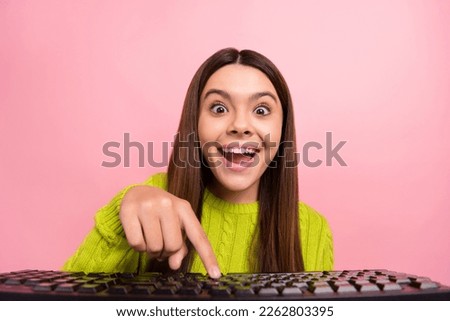 Photo portrait of cute young girl press key keyboard type funky face fooling wear trendy green garment isolated on pink color background