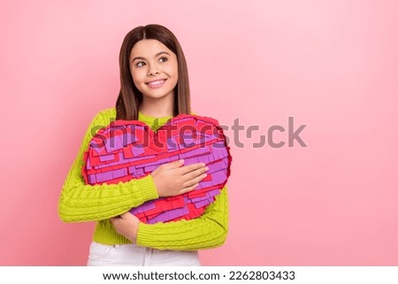 Photo of cheerful schoolgirl arms hold big heart collage look empty space isolated on pink color background