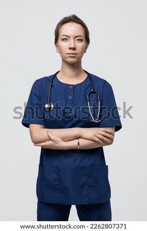 Smiling medical staff of the hospital. A young woman in a medical suit looks at the camera