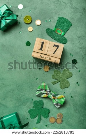 Frame made of decor, calendar, gifts and coins on green background. St. Patrick's Day celebration