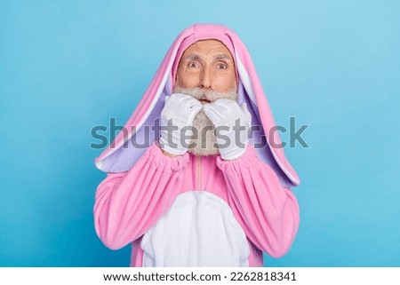 Photo of upset afraid retired man wear pink hare pajama biting hands arms fingers isolated blue color background